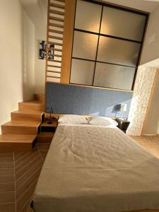 a bedroom with a large bed and a staircase at View Room in Bacoli +11 photos