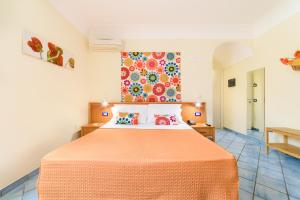 a bedroom with a bed with an orange bedspread at Sharon House in Amalfi