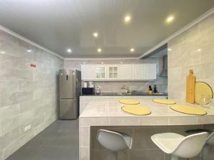 eine Küche mit einer Theke und einem Kühlschrank in der Unterkunft Brisa do Mar in São Roque