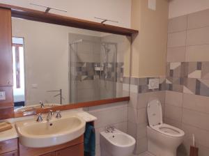 een badkamer met een wastafel, een toilet en een spiegel bij Sette cuscini affittacamere in Porto Recanati