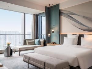 a hotel room with a bed and a couch at Pullman Jiaxing Pinghu Excellence in Jiaxing