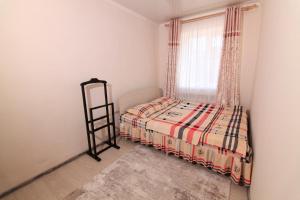 a small bedroom with a bed and a window at Nomads Home in Bishkek