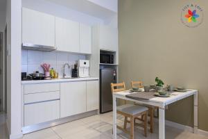 a white kitchen with a table and a refrigerator at KLCC Luxury Suite @ Chambers by Lily and Loft in Kuala Lumpur