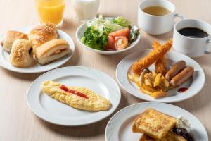 una mesa con platos de comida y una taza de café en Hotel Vista Nagoya Nishiki en Nagoya
