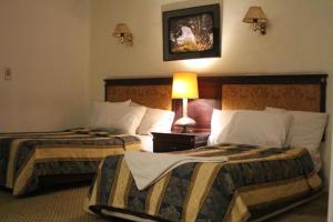 una habitación de hotel con 2 camas y una lámpara en The New Garden Palace Hotel en El Cairo