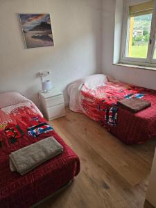 a bedroom with two beds and a window at Apartamento rural in Pravia +3 photos