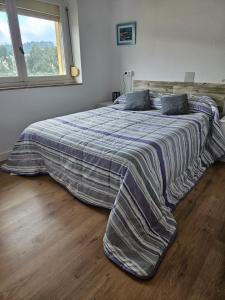 1 dormitorio con 1 cama con manta y ventana en Apartamento rural, en Pravia