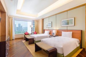 una camera d'albergo con due letti e una finestra di The Ritz-Carlton, Shenzhen a Shenzhen