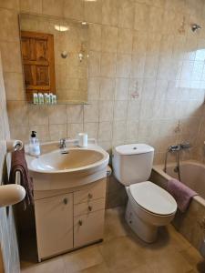 y baño con aseo, lavabo y bañera. en Apartamento rural en Pravia