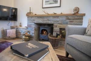 a living room with a fireplace and a book on a table at Church View in Nunnington