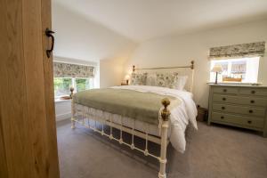 a bedroom with a large bed and two windows at Church View in Nunnington