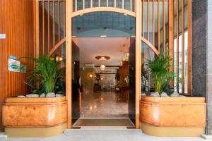 un corridoio in un edificio con due piante in vaso di Continental B&B City Hotel a Bibione