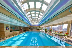 a large swimming pool with a skylight and a ceiling at Renaissance Shanghai Pudong Hotel in Shanghai