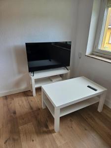 uma sala de estar com uma mesa de centro branca e uma televisão de ecrã plano em Apartamento rural em Pravia