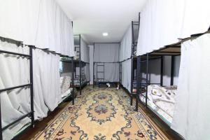 ビシュケクにあるNomads Homeの二段ベッドとラグが備わる客室です。