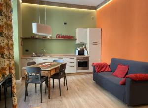 a living room with a table and a kitchen with a couch at Creton apartment -La casa nel cuore della città- CIR 0121 in Aosta