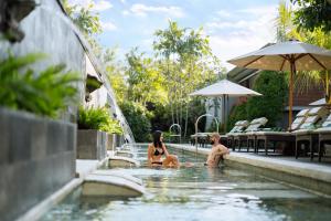 un hombre y una mujer sentados en una piscina en Bali Dynasty Resort en Kuta