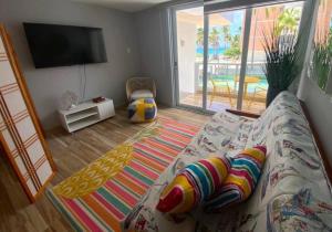 Una sala de estar con un sofá y un televisor de pantalla plana. en Kasa Balcony View, en San Juan