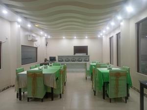 a large room with green tables and chairs in it at SeaScape Port Blair in Port Blair