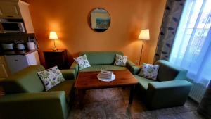 Selfness Rožňava في روجنافا: غرفة معيشة بها كنبتين خضراء وطاولة