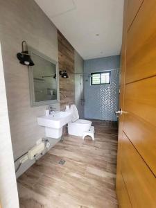 a bathroom with a white sink and a toilet at Lux 7 Pool Villa Mactan in Mactan