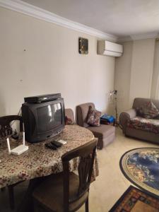 sala de estar con TV en una mesa en شقة مفروشة بالتجمع الخامس, en El Cairo