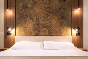 una camera da letto con un letto e un dipinto sul muro di Continental B&B City Hotel a Bibione