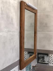 a mirror on a wall next to a sink at La Casa Mirissa in Mirissa
