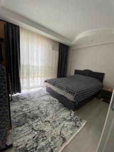 a bedroom with a bed and a large window at 2+1 MUHTEŞEM TATİL EVİ in Dalaman