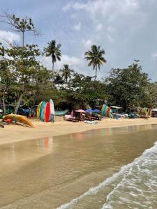 a beach with a bunch of umbrellas and the water at The Yard Hiriketiya in Hiriketiya +66 photos