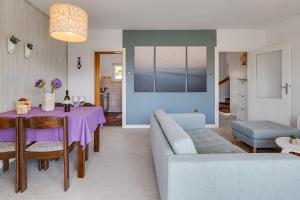a living room with a table and a couch at Villa Silencia 200 m do mora jacuzzi besplatni parking idealno za obitelj in Pag