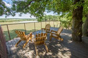 3 Stühle und ein Tisch auf einer Terrasse mit einem Baum in der Unterkunft Parc Animalier de Sainte-Croix in Rhodes