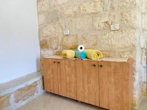 a wooden cabinet with towels and a stuffed animal on it at Dar Ateeq's Arches/ Bethlehem Apartment in Bethlehem