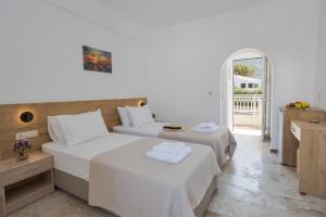 a hotel room with two beds and a balcony at Amara Seaside by Estia in Malia