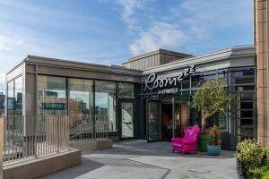 爱丁堡Roomzzz Edinburgh的商店前的粉红色椅子