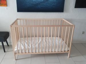 a crib with a white mattress in a room at Airbnb-lejligheder, Villerslev in Villerslev