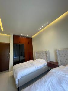 a bedroom with two beds and a room with a window at Rateel Apartments in Salalah