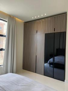 1 dormitorio con 1 cama y puerta corredera de cristal en Rateel Apartments en Salalah