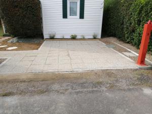 a driveway with a white house and a red pole at MOBIL HOME dans Parc résidentiel Loisirs in Talmont