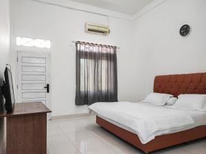 ジャンビにあるAdela Homestay Syariah Near Universitas Muhammadiyah Jambi Mitra RedDoorzのベッドルーム(ベッド1台、テレビ、窓付)