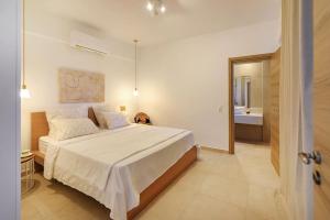 Habitación blanca con cama y baño. en Dilean luxury villa en Vourvourou