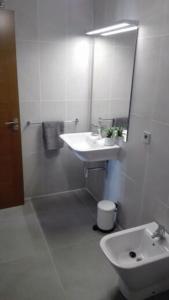 ein weißes Badezimmer mit einem Waschbecken und einem Spiegel in der Unterkunft First Class Holiday Tejita WiFiber in Granadilla de Abona