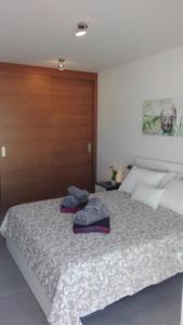 a bedroom with a bed with two hats on it at First Class Holiday Tejita WiFiber in Granadilla de Abona