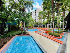 a pool at a resort with palm trees at Nara lahabana in Hua Hin