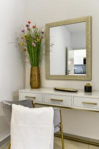 a white dresser with a mirror and a vase with flowers at Ivy Apartments in Zadar