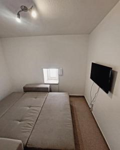 - une chambre avec un lit et une télévision à écran plat dans l'établissement Casa do Fundo do Povo - Serra da Estrela, à Cortes do Meio
