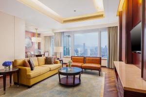 a living room with a couch and a tv at The Ritz-Carlton, Shenzhen in Shenzhen