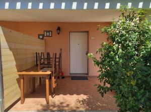 a porch with a table and chairs and a white door at Sa Teria Village - Appartamenti - in Tertenìa