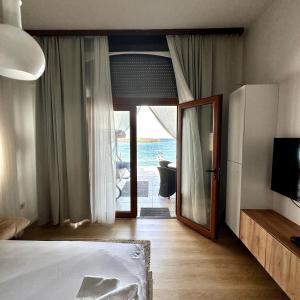 um quarto com uma cama e uma porta de vidro deslizante em Apartments Lungo Mare em Sveti Stefan