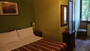 una camera con un letto in una stanza con pareti verdi di Hotel Europa a Perugia